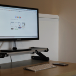 A monitor sitting on top of a desk riser, open to Google