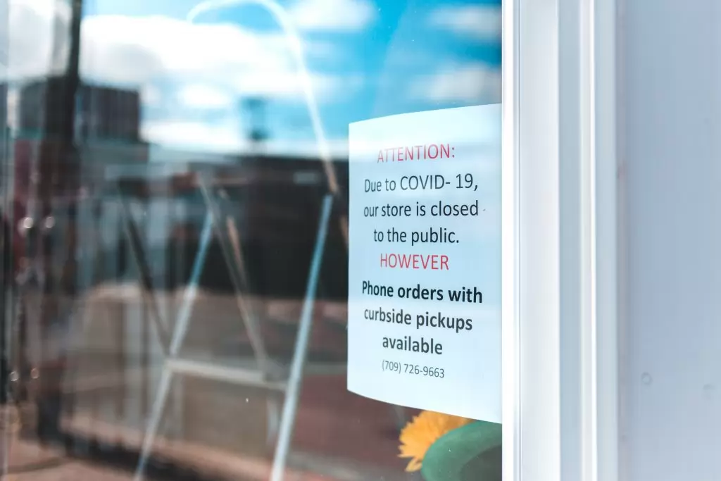 A sign hanging in a business window stating that it's only accepting online and phone orders, demonstrating a need for effective e-commerce products.