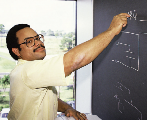 Mark Dean, a Black leader in tech history, writing on a chalkboard