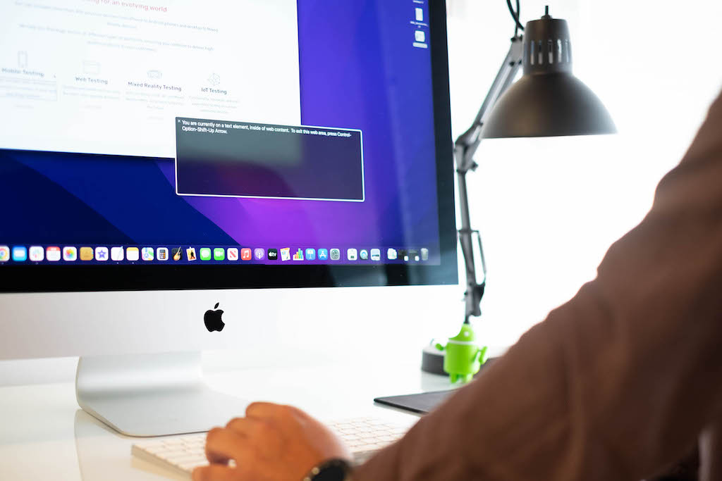 A person using VoiceOver on an iMac, demonstrating the need for accessibility testing.