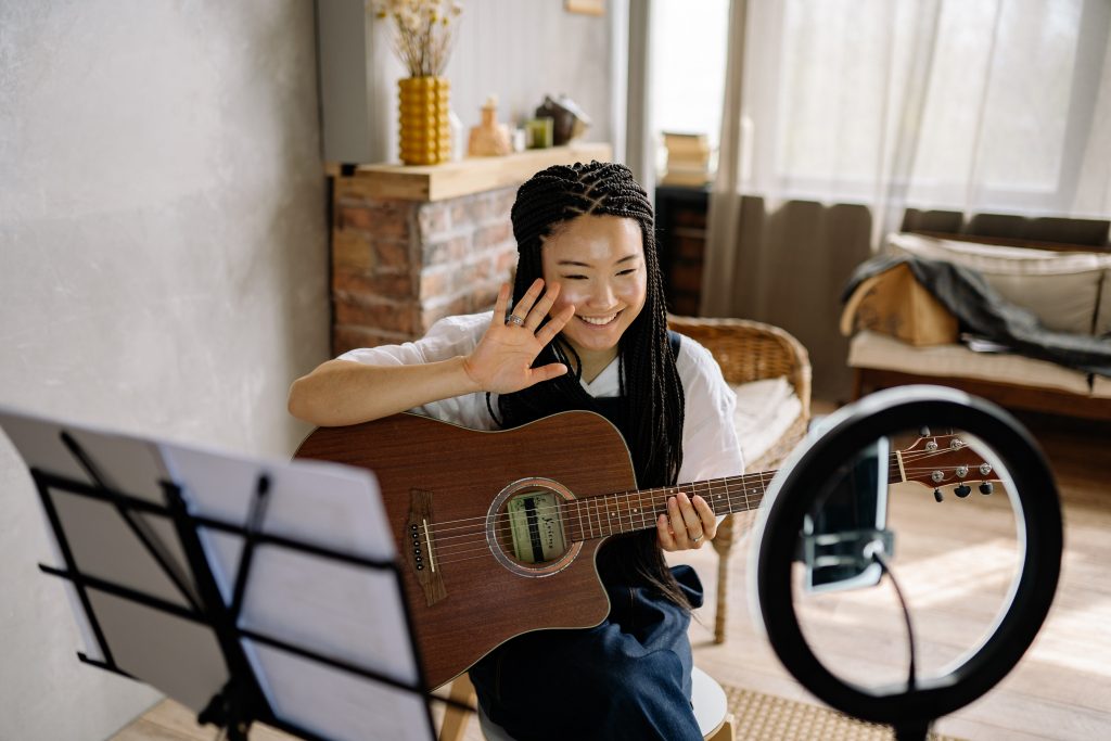 A girl playing a guitar and streaming herself