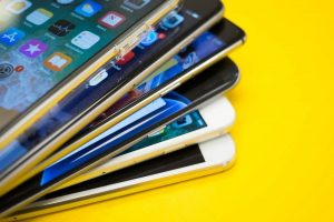 A stack of mobile devices on top of a yellow background